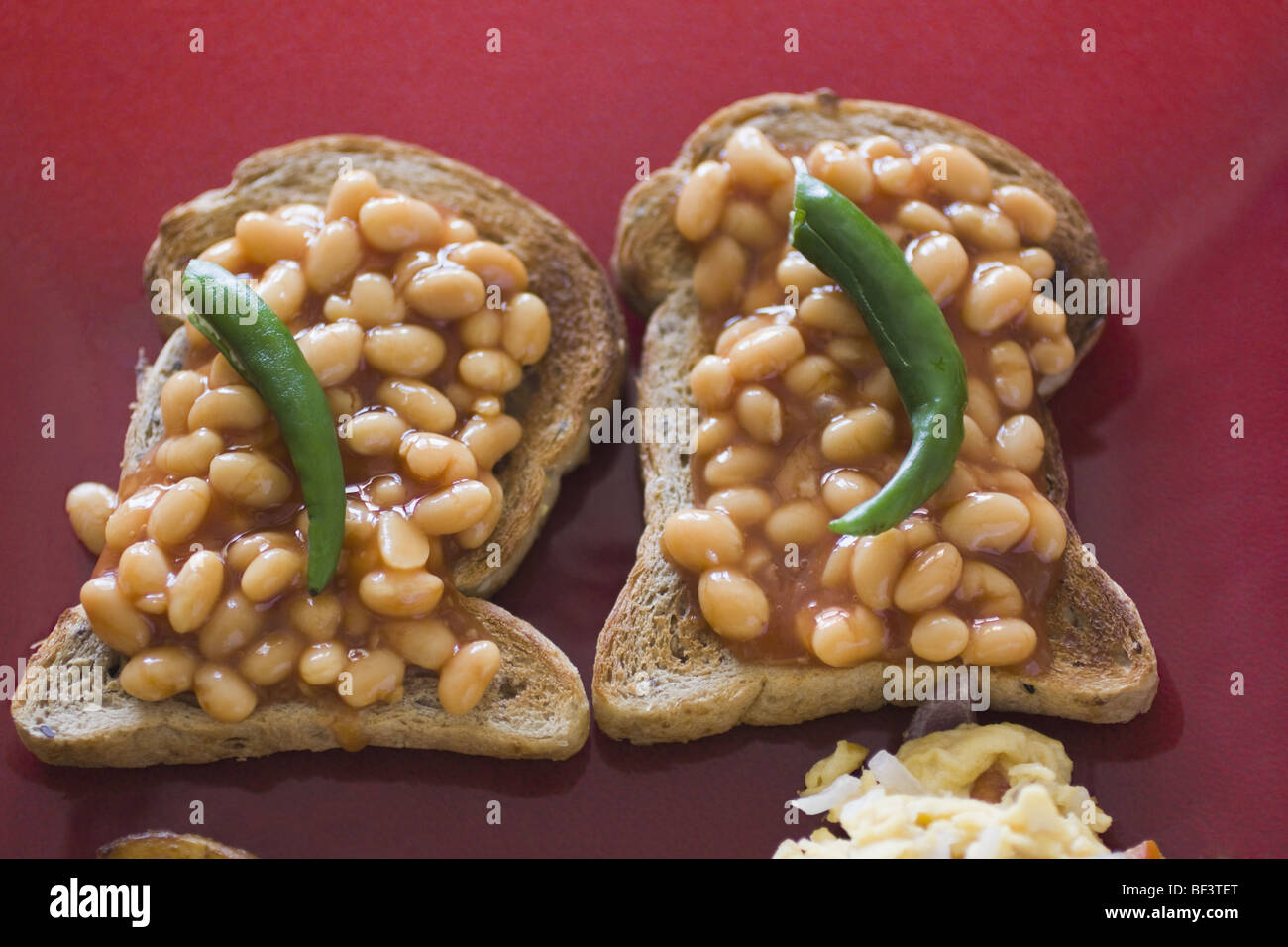 Close up of baked beans on toasts with green chillies hires stock