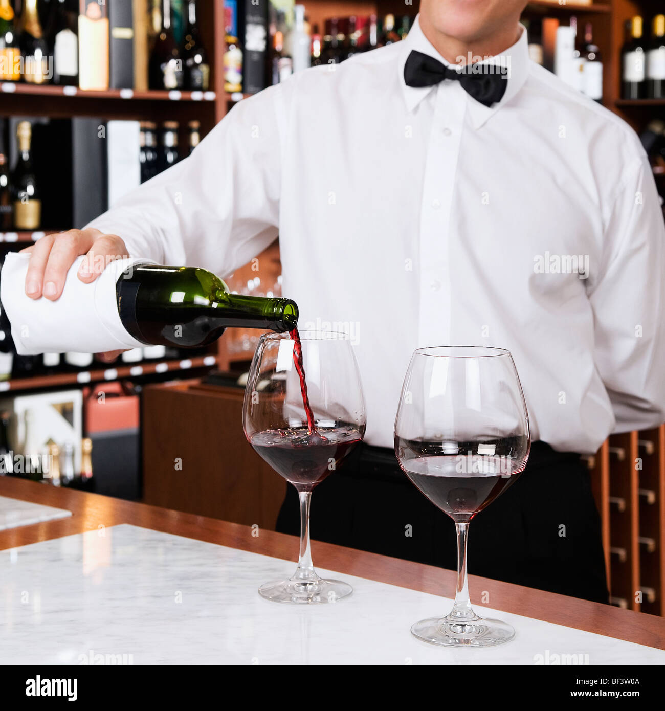 Waiter pouring wine into a glass Stock Photo Alamy