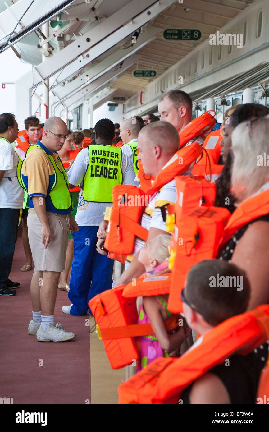 Cruise ship passengers with life vests perform mandatory muster station safety drill before leaving port on Caribbean cruise Stock Photo