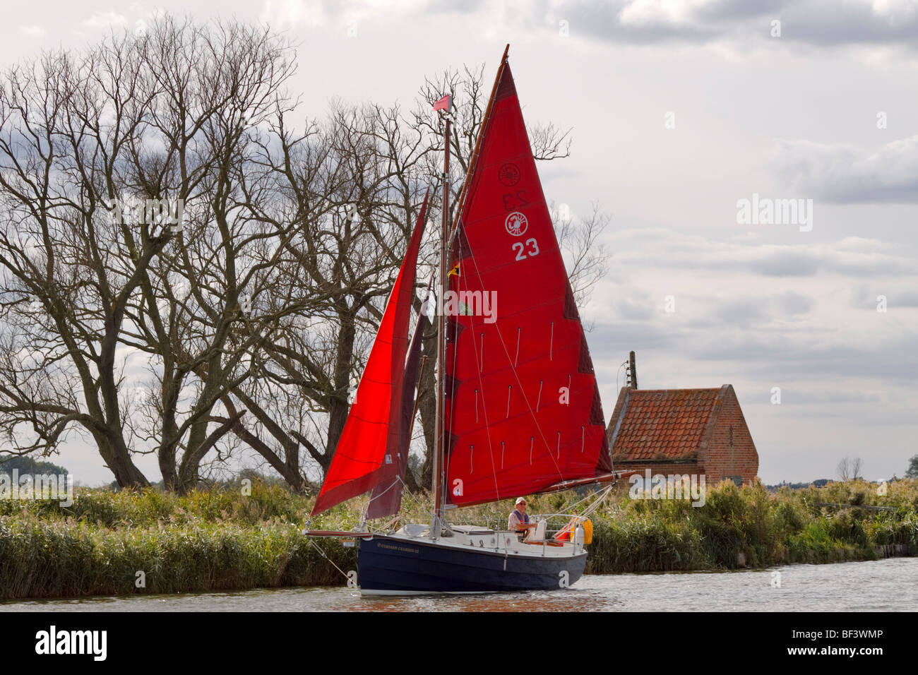 Yacht with red sails on the River Bure, Norfolk Stock Photo