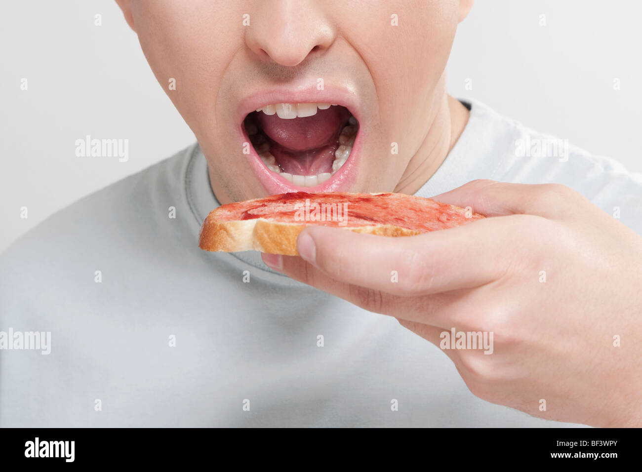 Man eating jam on toast Stock Photo Alamy