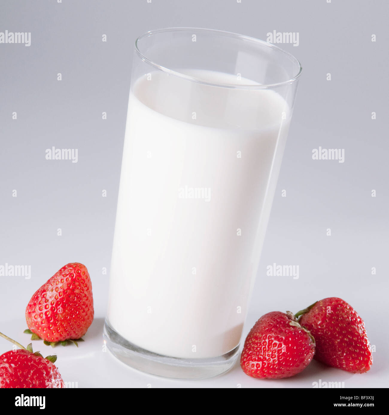 Close-up of a glass of milk and strawberries Stock Photo