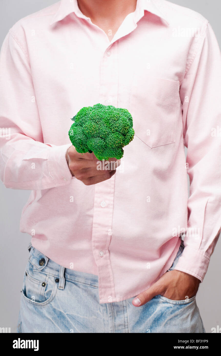 Mid section view of a man holding a broccoli Stock Photo