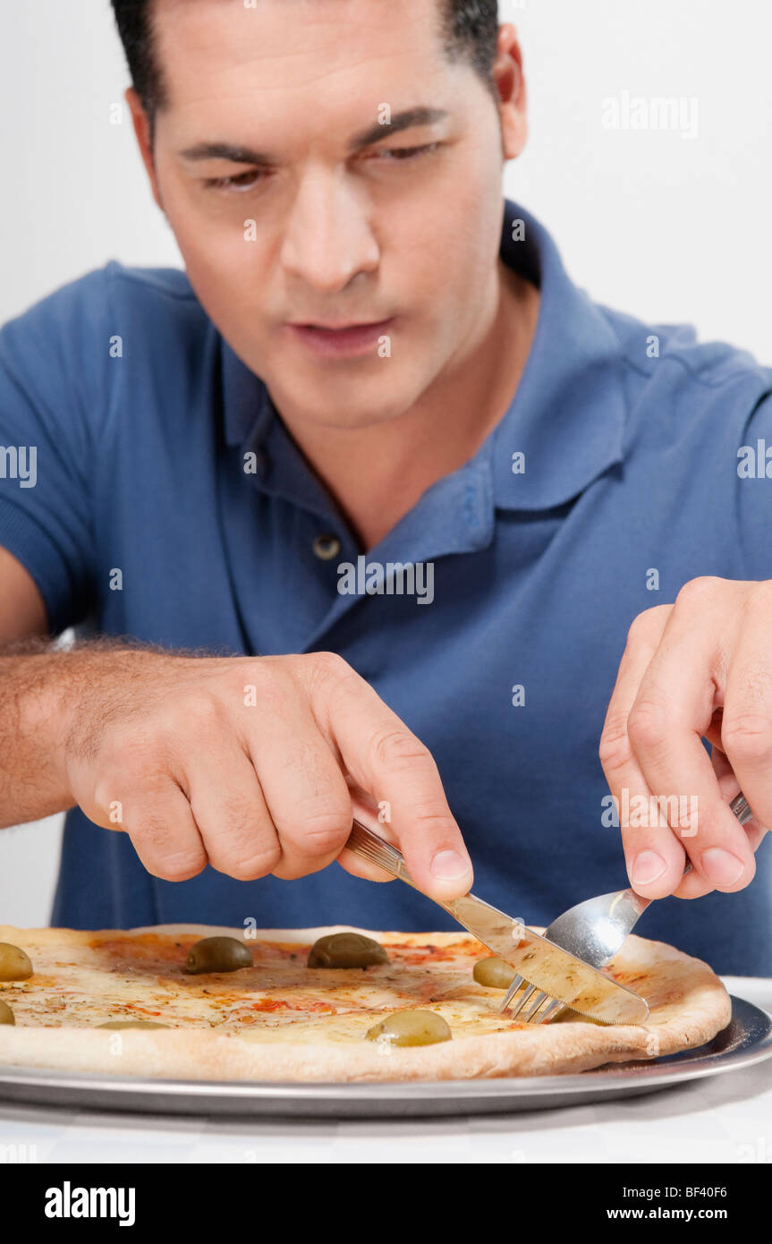 Man eating pizza with a fork and knife Stock Photo Alamy