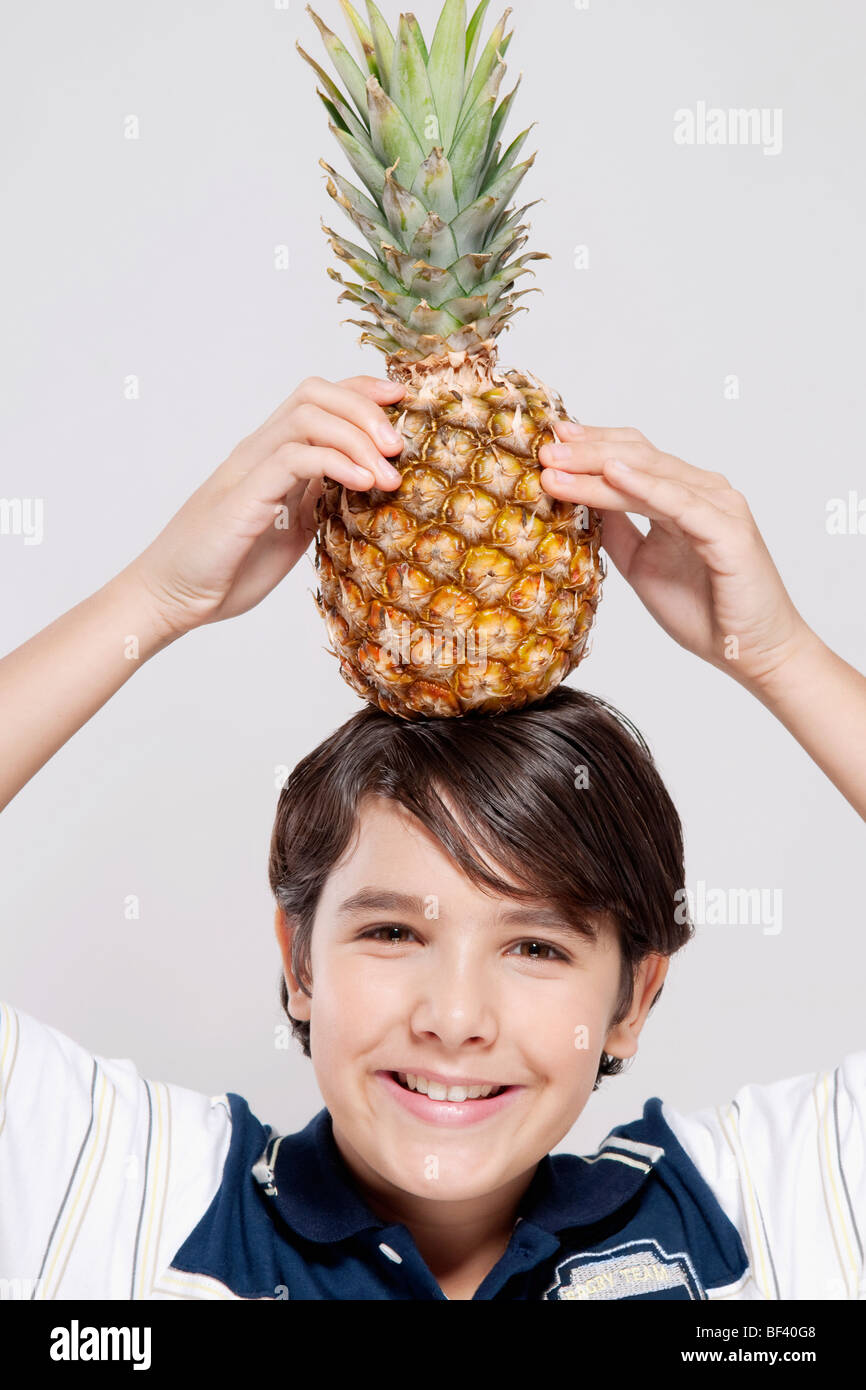 Portrait of a boy carrying a pineapple on his head Stock Photo Alamy