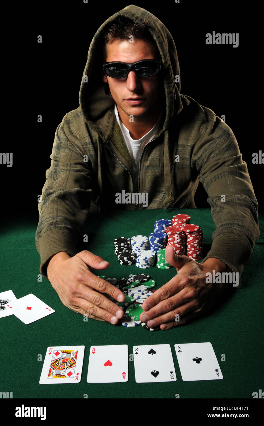 Poker player with sunglasses gathering winning chips Stock Photo