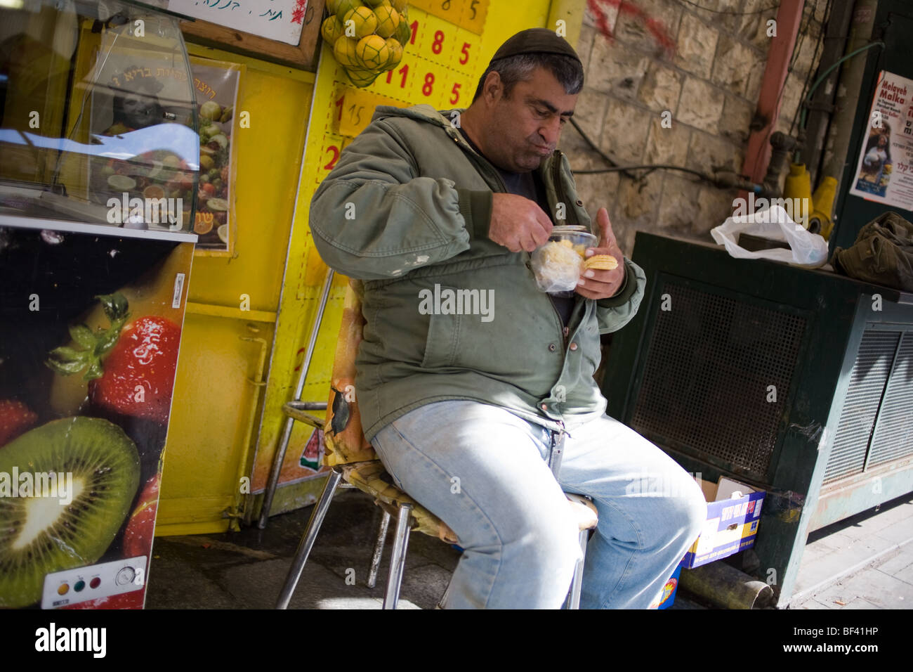 A Man Having a Snack at Machane Yehuda Market in Jerusalem Israel Stock Photo