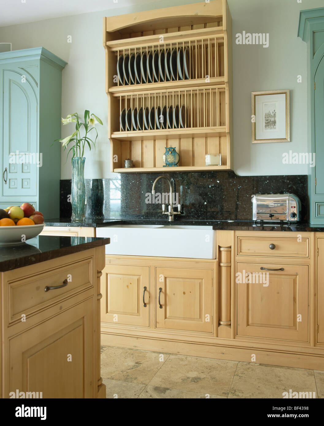 Pale wood plate-rack and granite splash-back above Belfast sink in ...