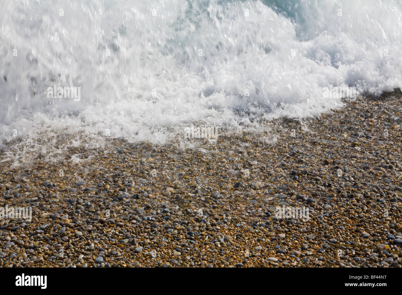 Wave crashing on a pebble beach Dorset England Stock Photo