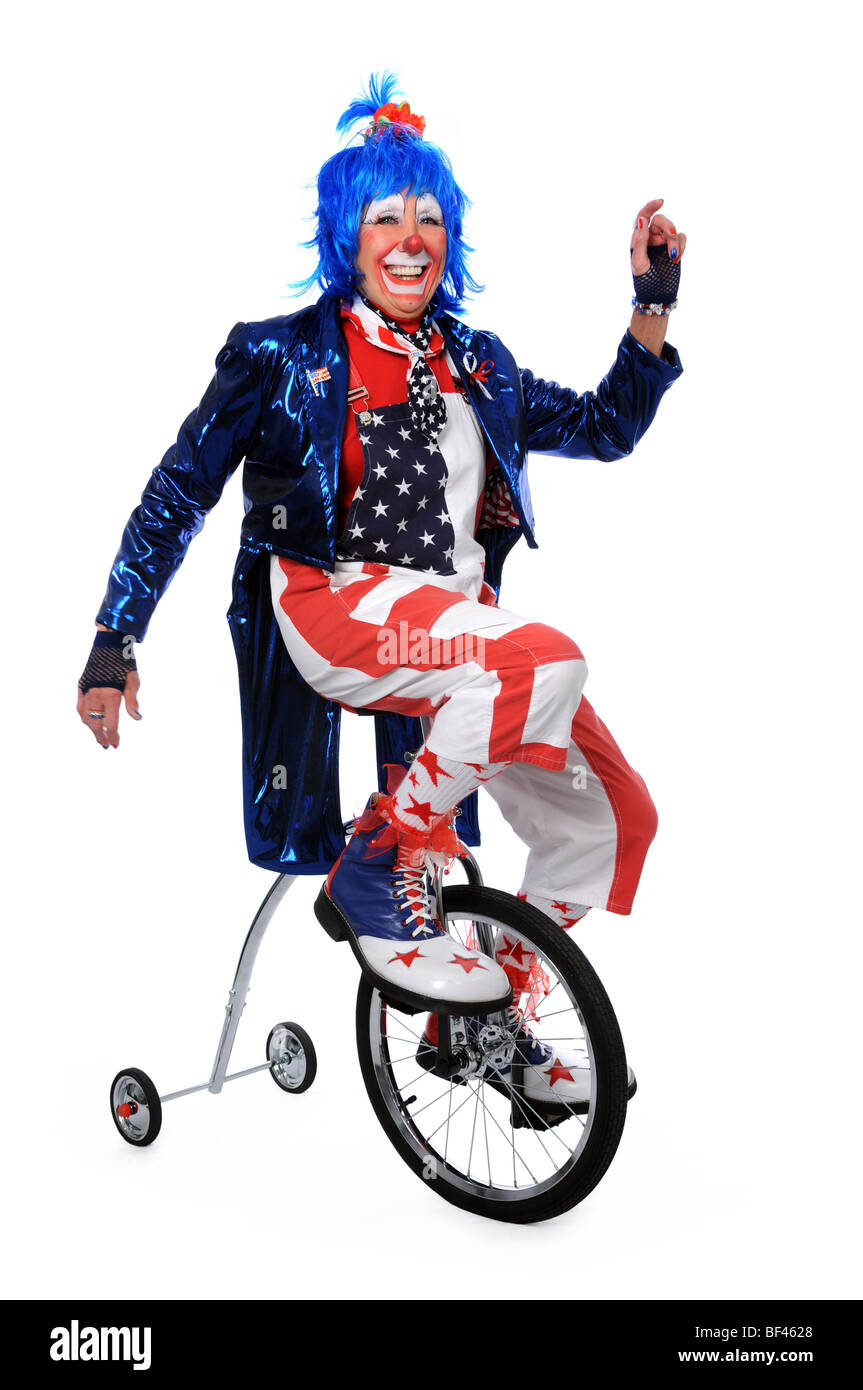 Clown riding a unicycle with training wheels Stock Photo