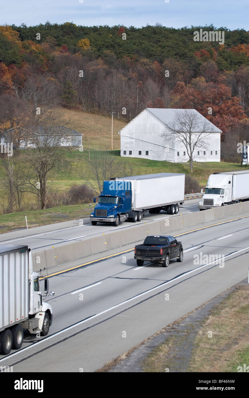 Tractor trailer truck traffic on an American interstate road, the Pennsylvania Turnpike. Stock Photo