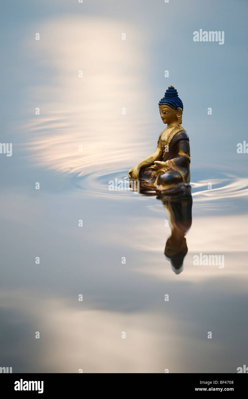 Buddha statue floating on calm still water surface in India Stock Photo