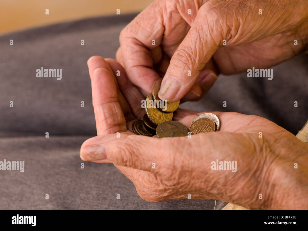 elderly Caucasian woman counting coins in her hands Stock Photo