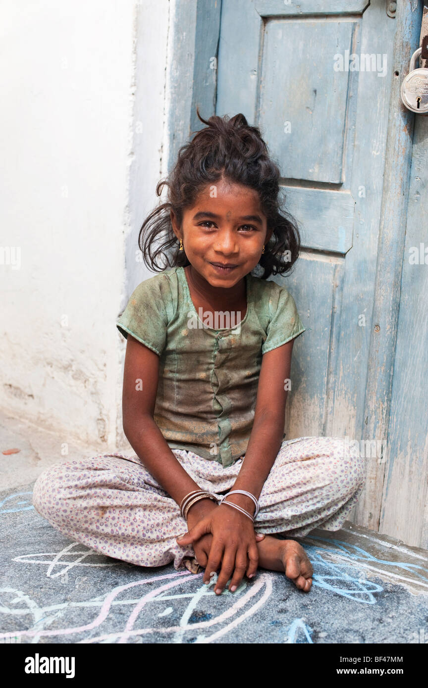 Young Indian street girl sitting by a door in an Indian street Stock Photo