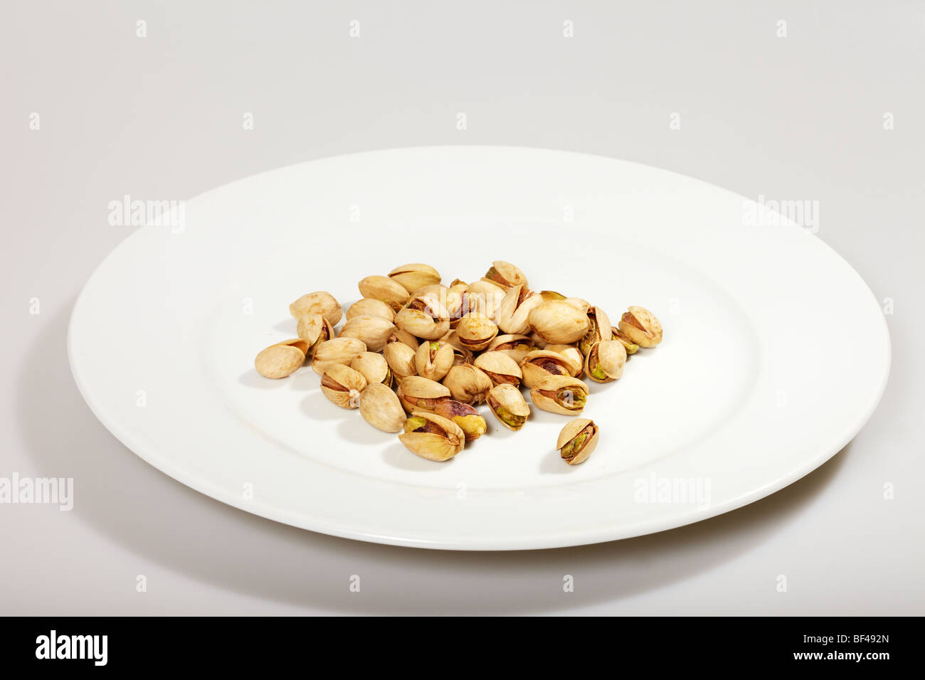 Pistachio Nuts on a White Plate Stock Photo