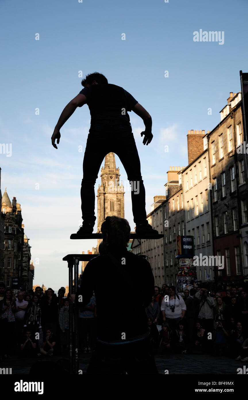 silhouette of a man street performer balancing act finely balanced crowd Edinburgh fringe street festival tilt Stock Photo