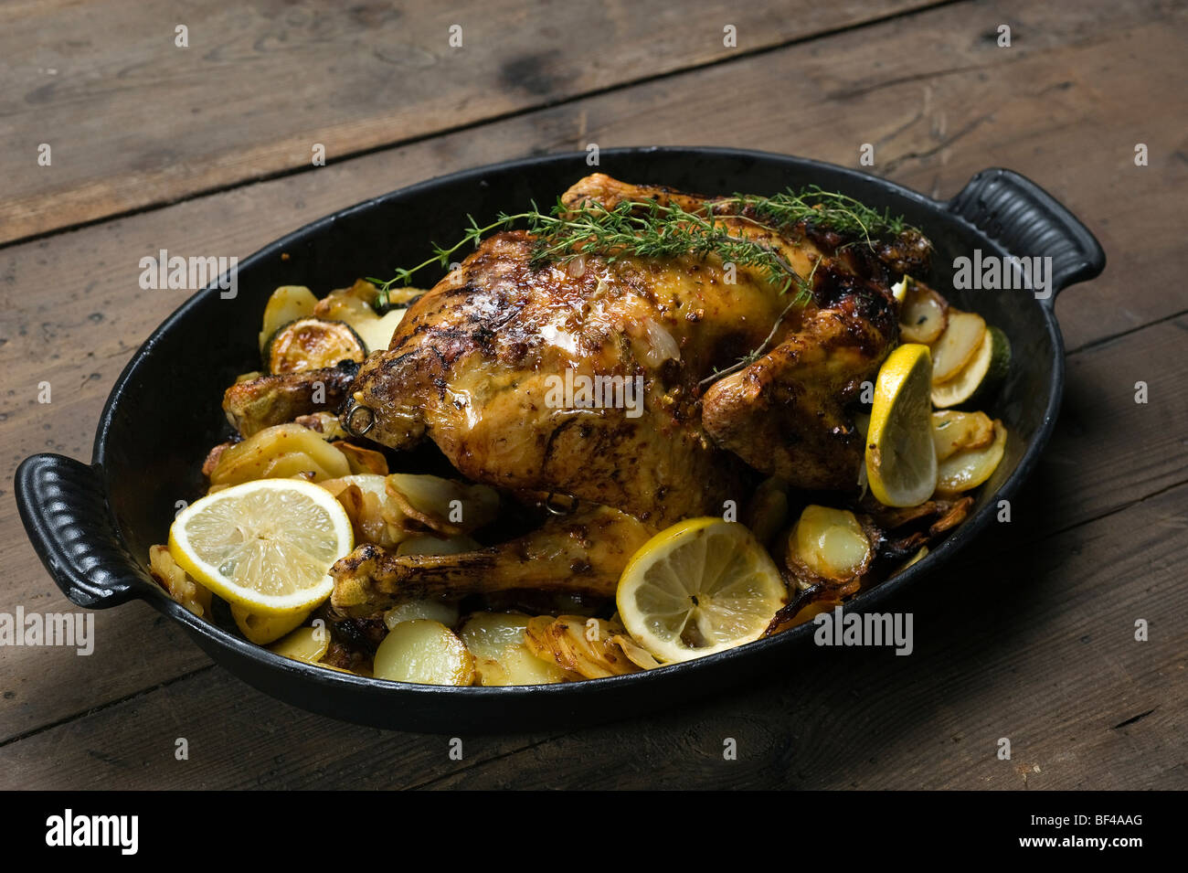 Lemon chicken with thyme and potato gratin Stock Photo