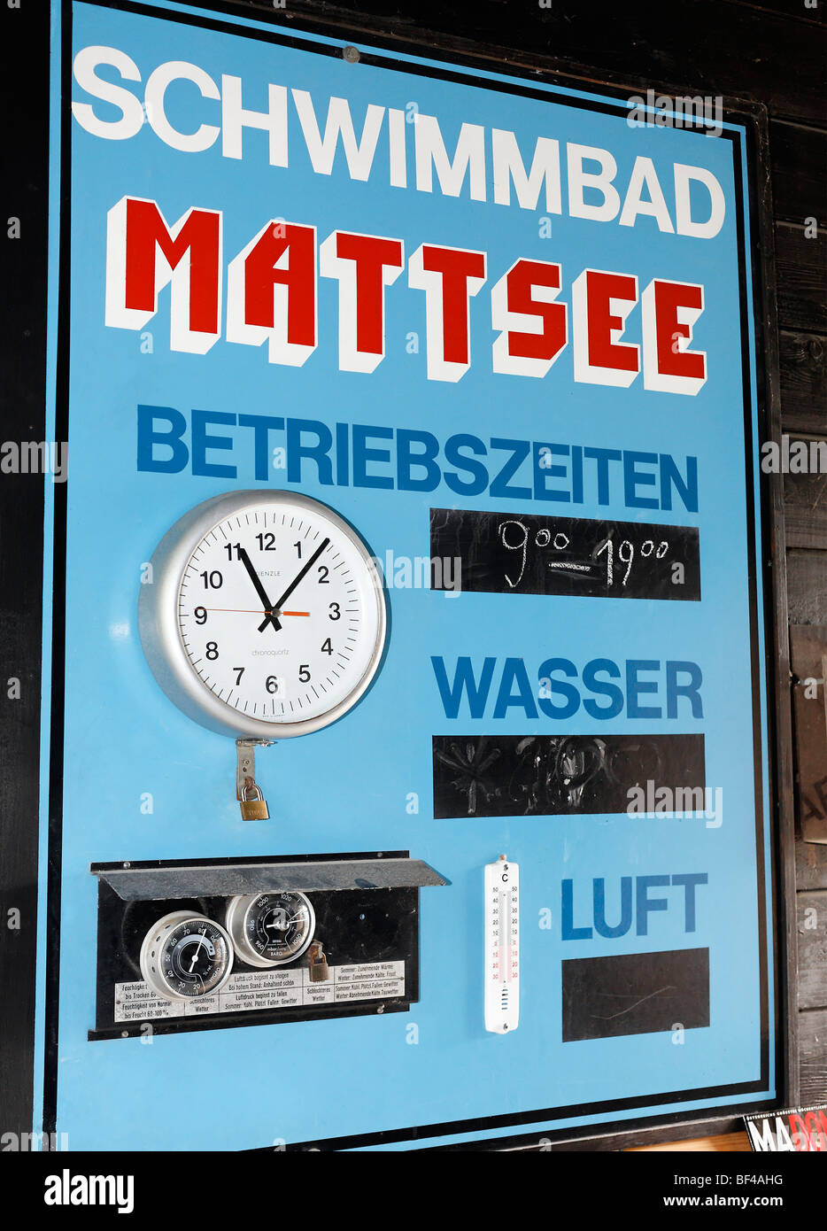 Historic lido from 1927, sign with operating times and water and air temperatures, with clock, Mattsee, Flachgau, Salzburger La Stock Photo