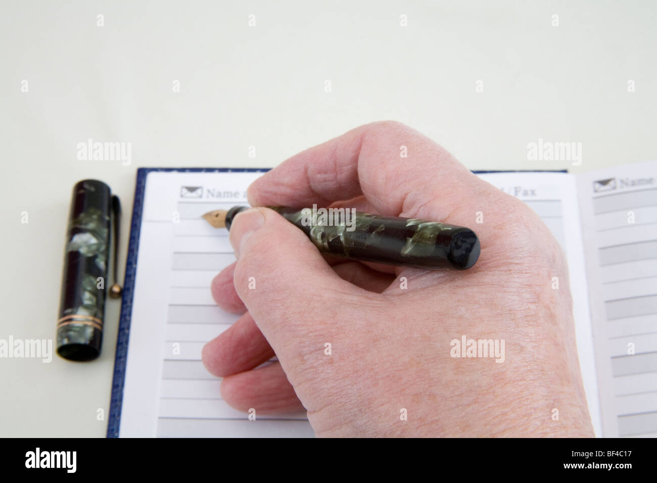 Studio Close up Woman's hand holding a vintage fountain pen poised to ...