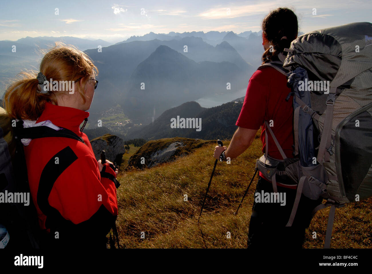 Hikers, woman and man with tour backpacks and trekking poles on the top of Mt. Heidachstellwand, 2192m, overlooking the Inn Val Stock Photo