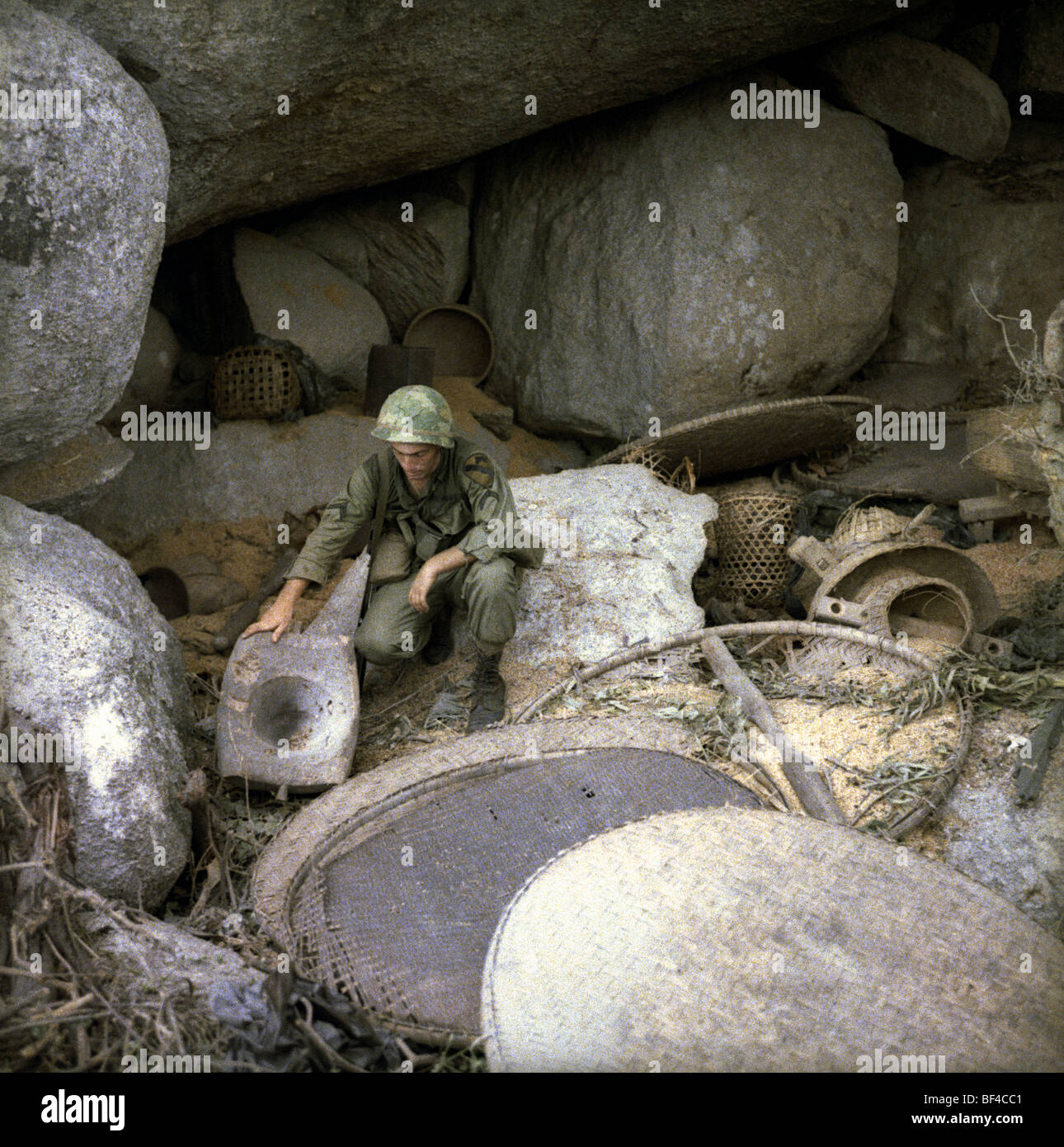 An infantryman of B Troop, 1st Squadron, 9th Cavalry with a discovered NVA rice cache during the Vietnam War in 1967. Stock Photo