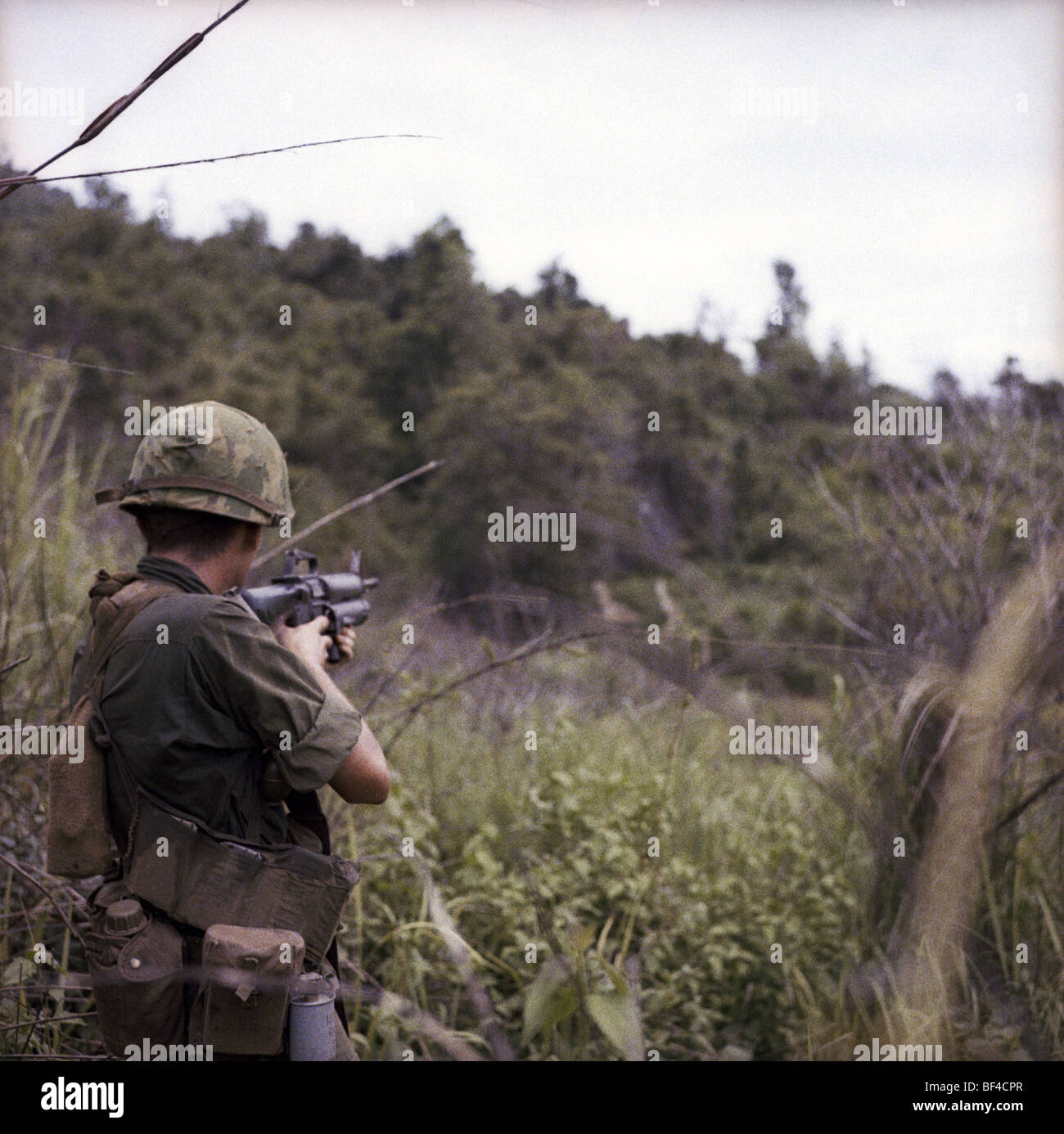 An infantryman of B Troop, 1st Squadron, 9th Cavalry fires an M16 at a jungle target during the Vietnam War in 1967. Stock Photo