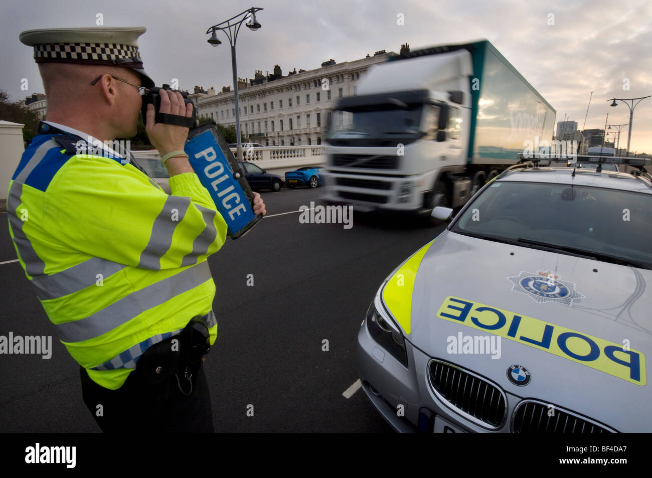 A police officer using a handheld laser camera on a city road to catch speeding motorists Stock Photo