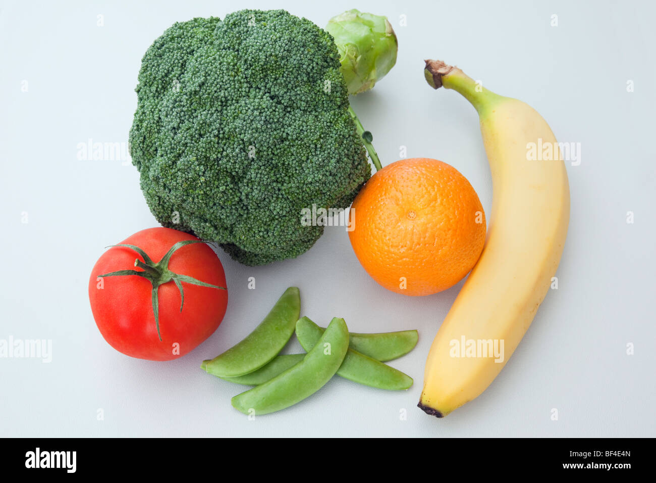 Five a day fresh fruit and vegetables, broccoli, tomato, mange tous, orange and banana for a healthy balanced diet Stock Photo