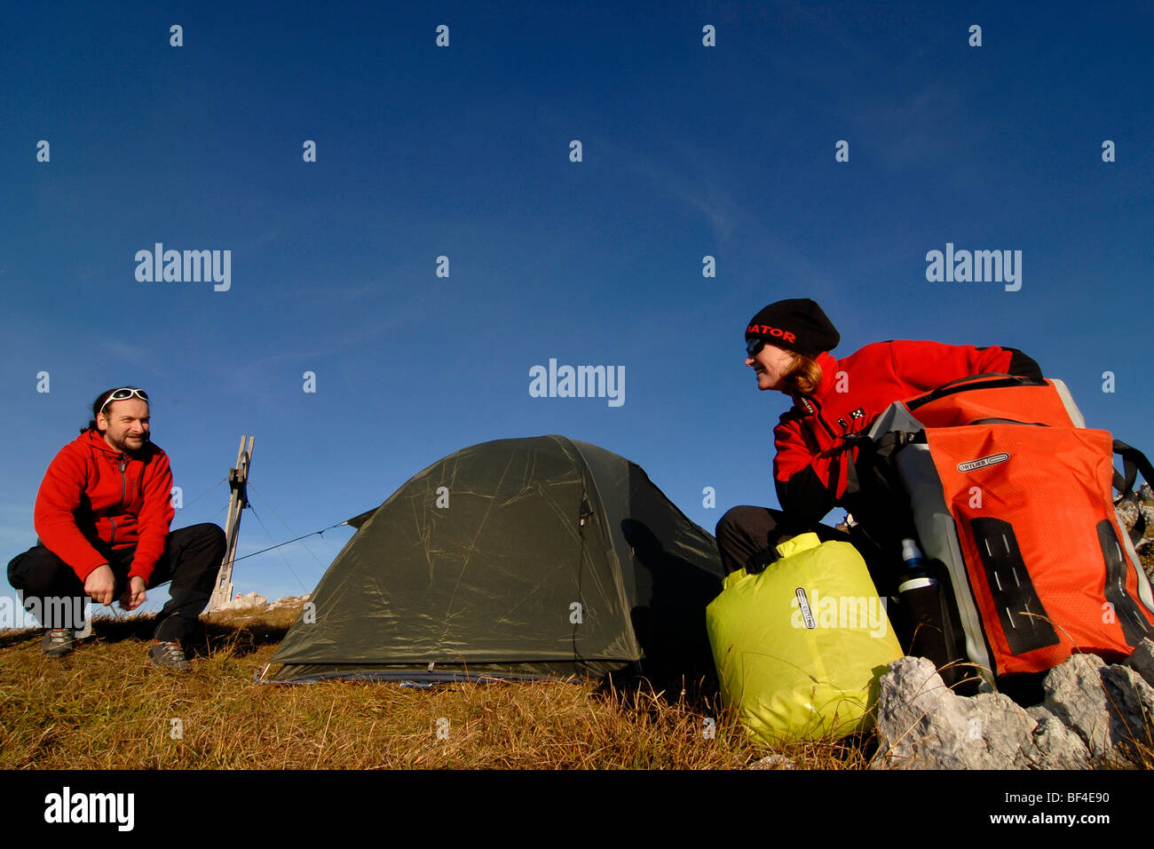 Hikers, young man and woman putting up a bivouac with tent, sleeping bag, backpack and sleeping pad, Heidachstellwand, Rofan, A Stock Photo