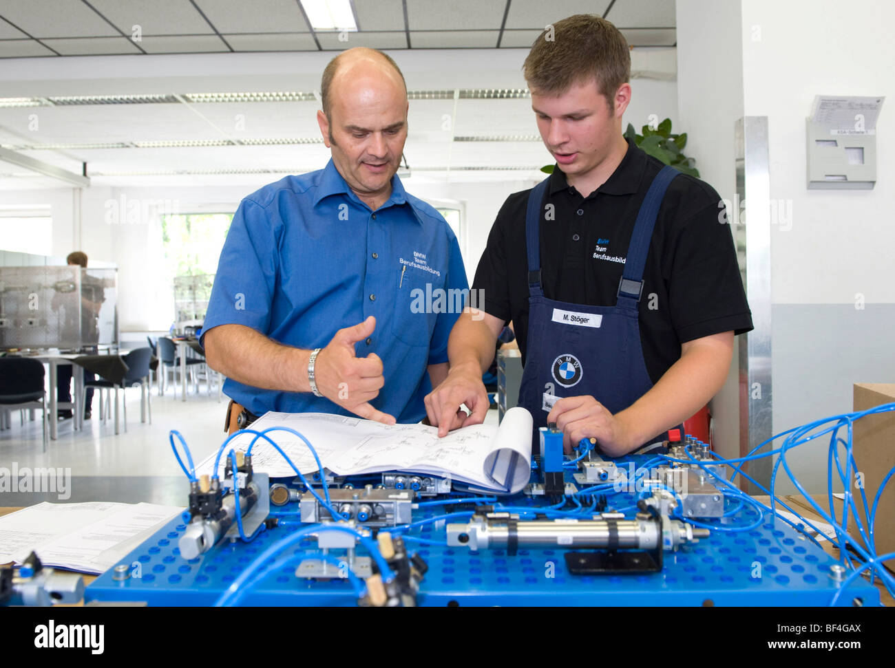 Master, Andreas Fischer, explaining an electric circuit to an apprentice in the BMW training center for automotive mechatronics Stock Photo