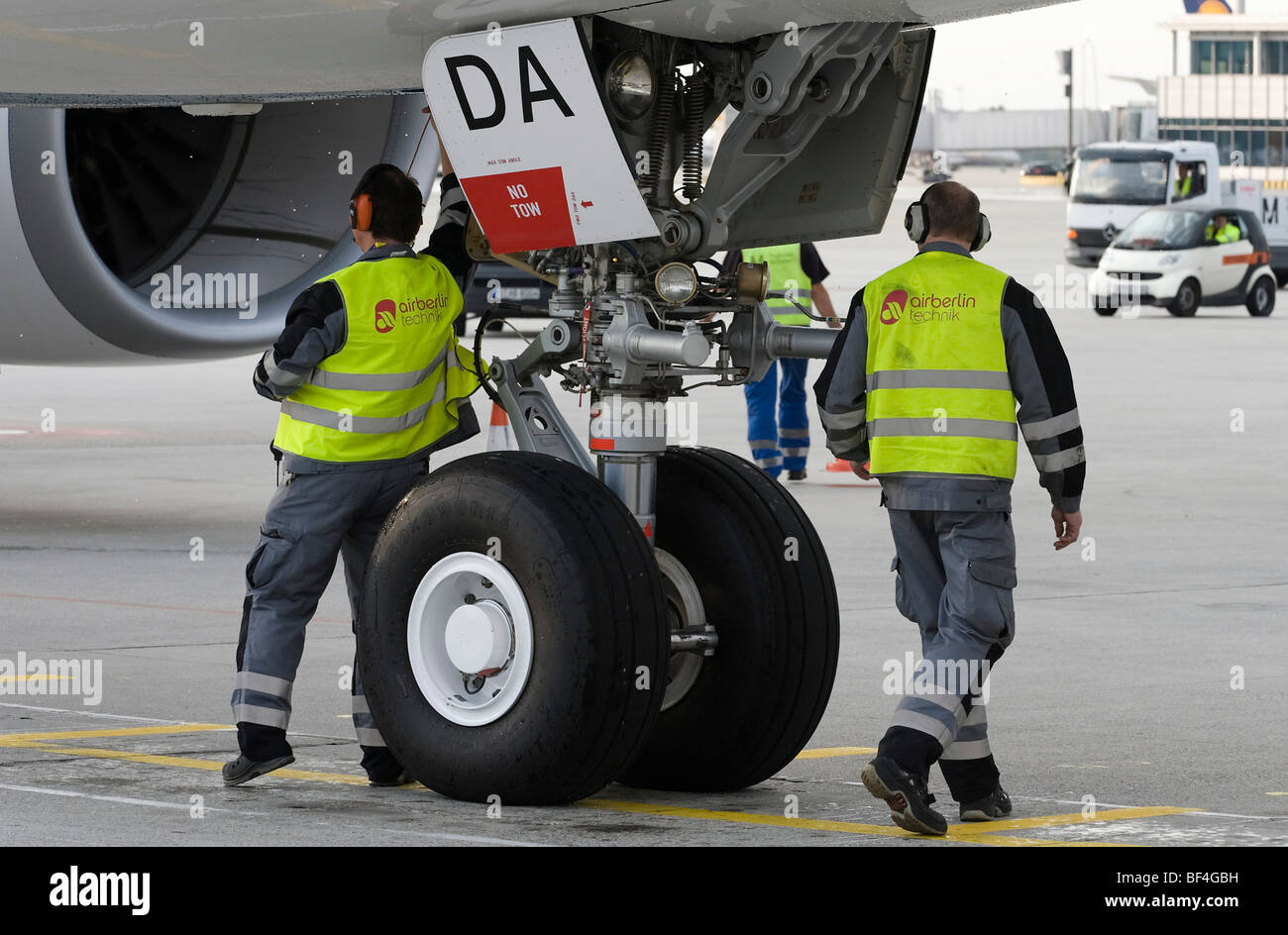 Technical ground crew working under an Airbus A330-200 of the airline Oman Air, Munich Airport, Bavaria, Germany, Europe Stock Photo