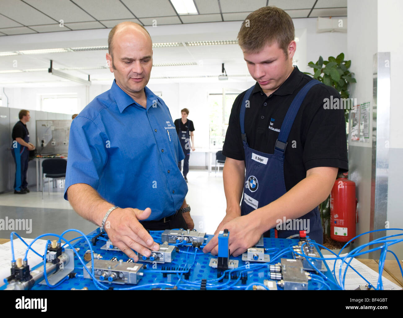 Master, Andreas Fischer, explaining an electric circuit to an apprentice in the BMW training center for automotive mechatronics Stock Photo