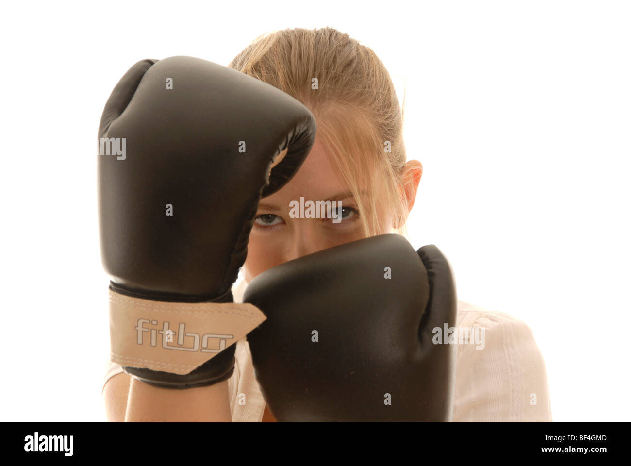 Eighteen year old woman with boxing gloves, taking cover, defensive Stock Photo