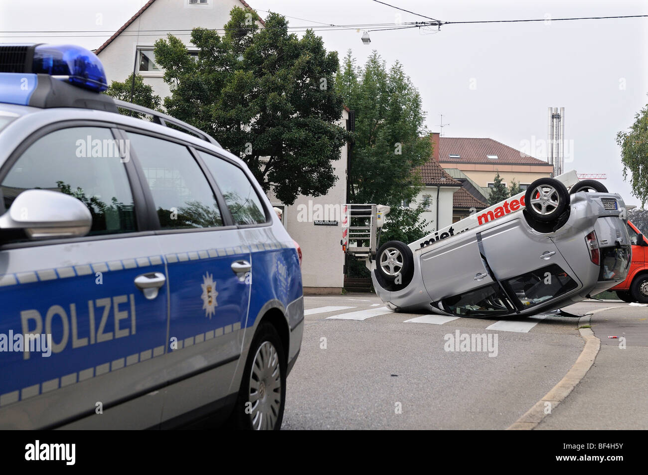 Daihatsu car having rolled over in a traffic accident, lying on its roof, patrol car in the foreground, Stuttgart, Baden-Wuertt Stock Photo
