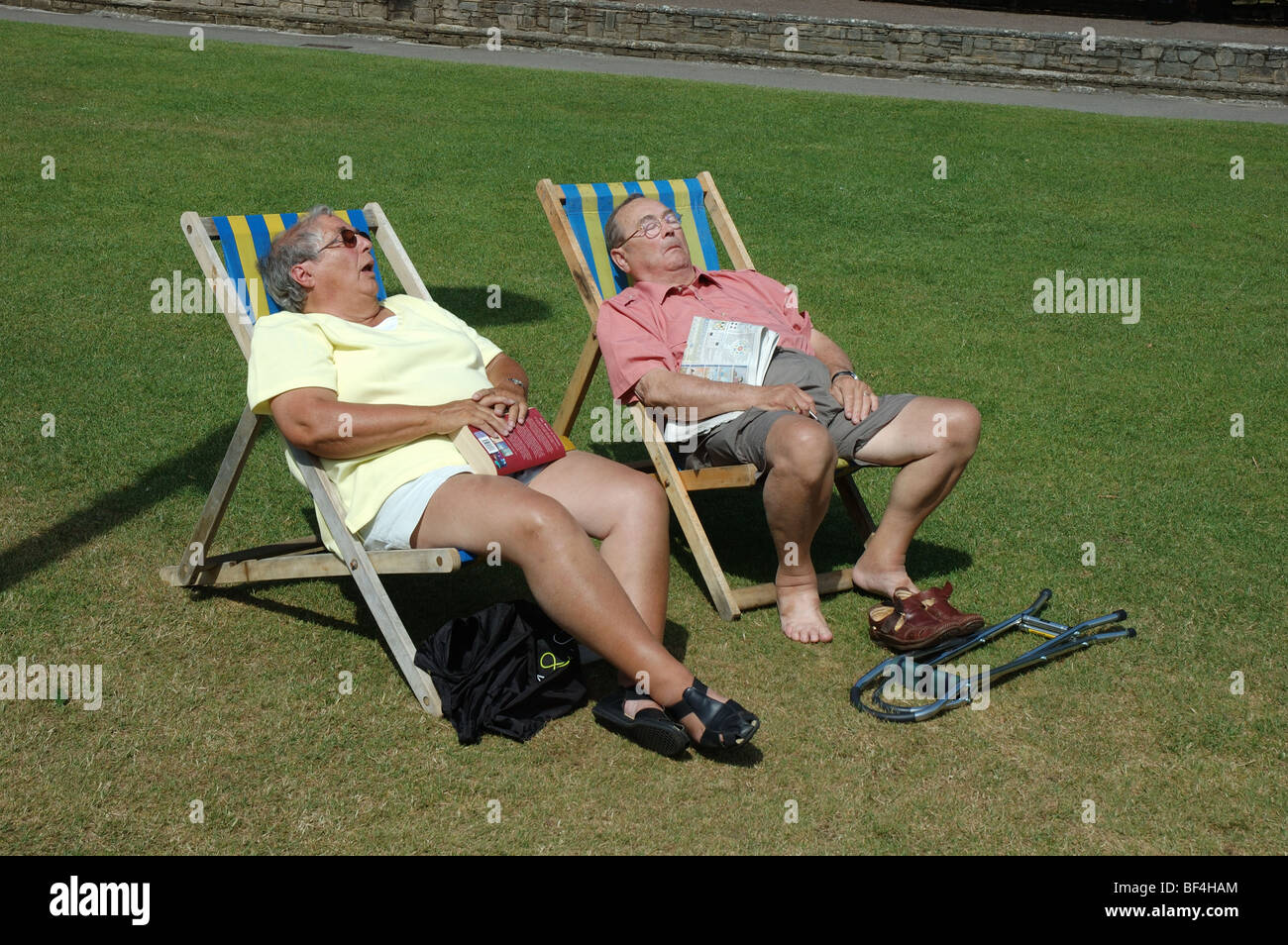 middle-aged couple sunbathing in deckchairs, Lower Gardens, Bournemouth, Dorset, England, UK Stock Photo