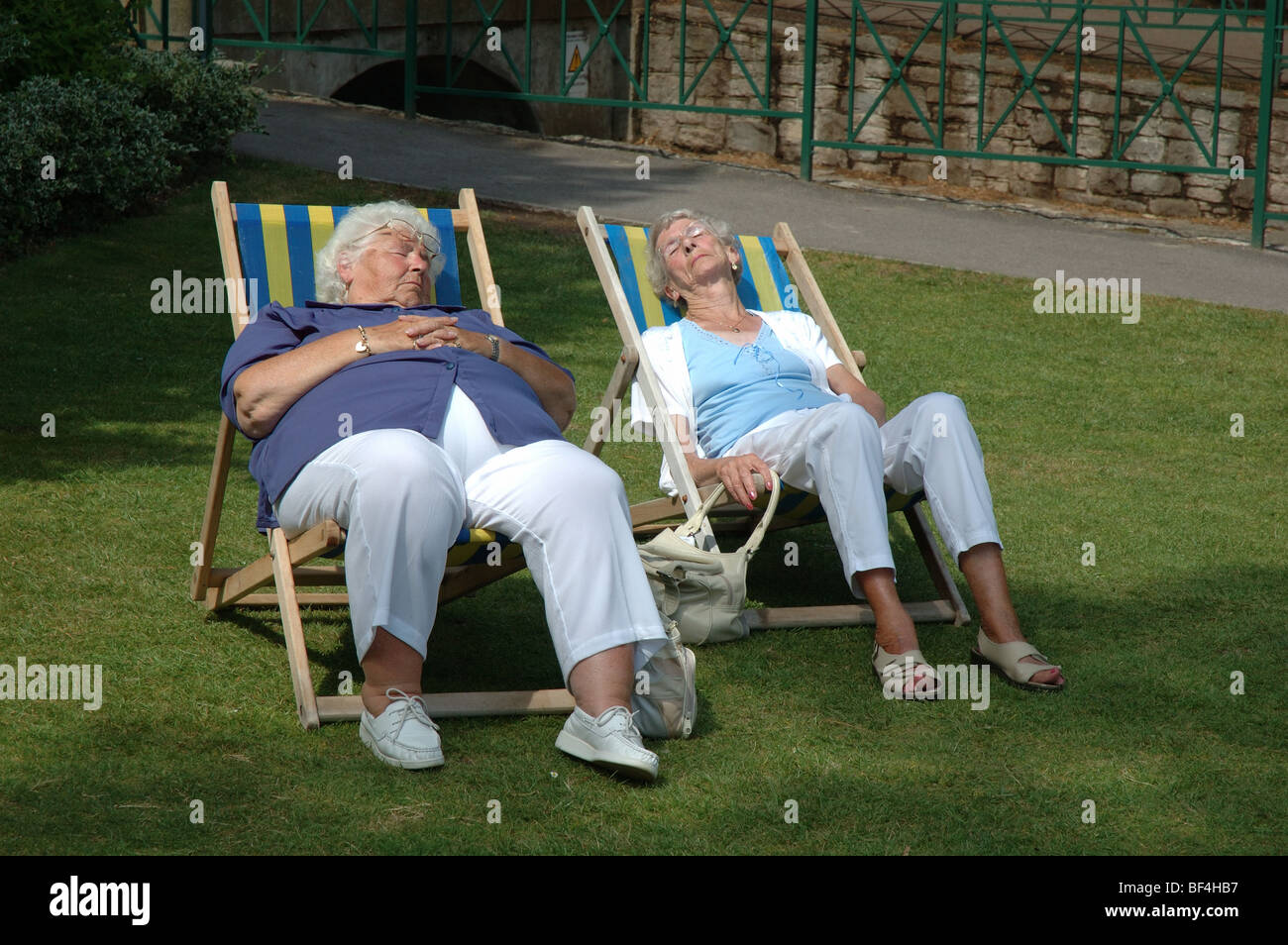 two elderly ladies sunbathing in deckchairs, Lower Gardens, Bournemouth, Dorset, England, UK Stock Photo