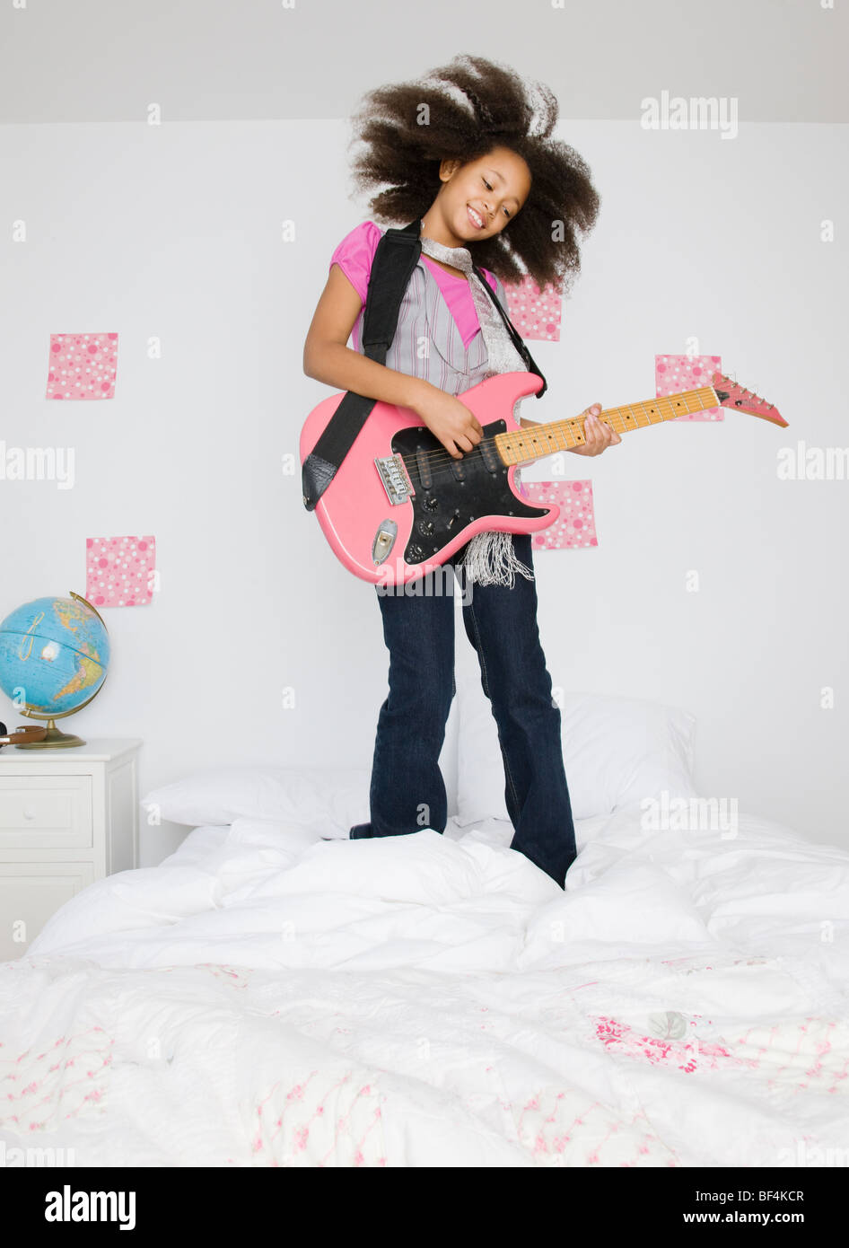 African girl playing guitar on bed Stock Photo Alamy