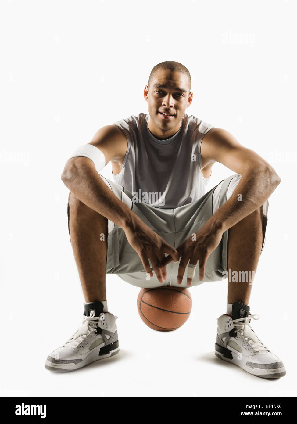 African man sitting on basketball Stock Photo