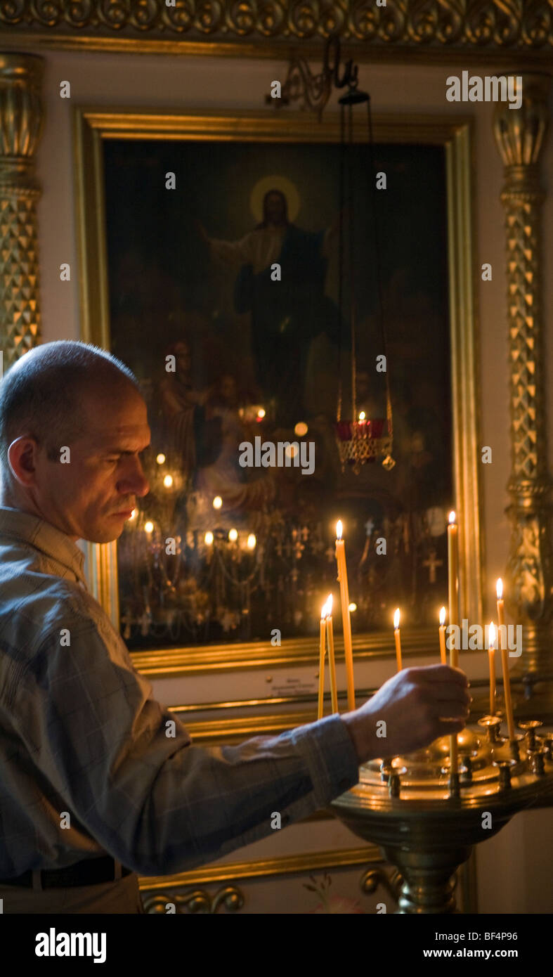 Man lighting candle at altar in Russian orthodox church, Ekaterinburg