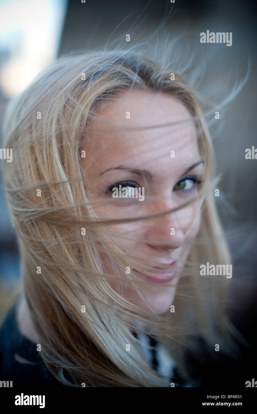 Wind blowing hair, blonde woman with green eyes Stock Photo