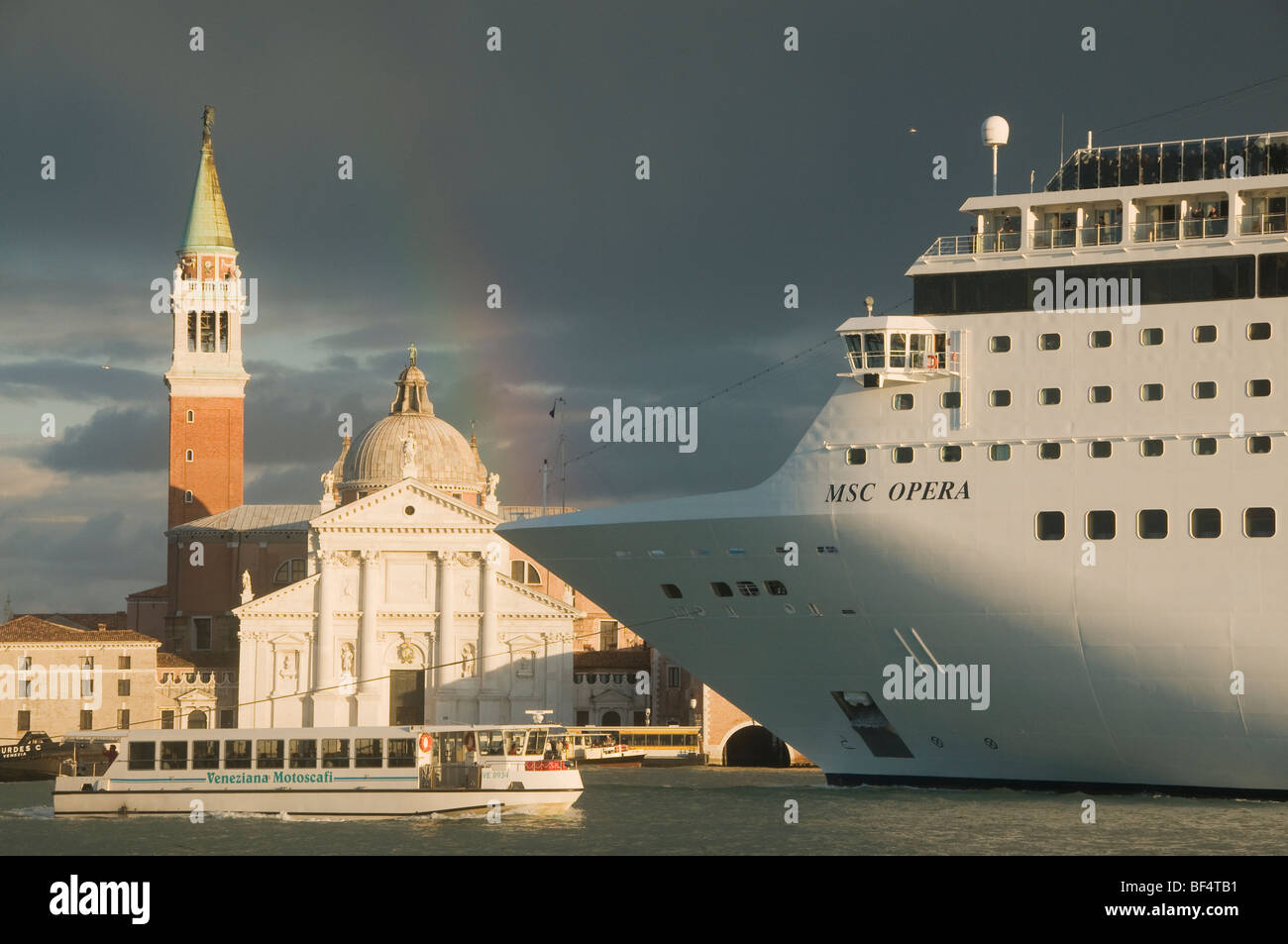 Italy, Venice, Vaporetto and MSC OPERA cruise ship pass San Giorgio Maggiore Church, Sunset with Rainbow Stock Photo