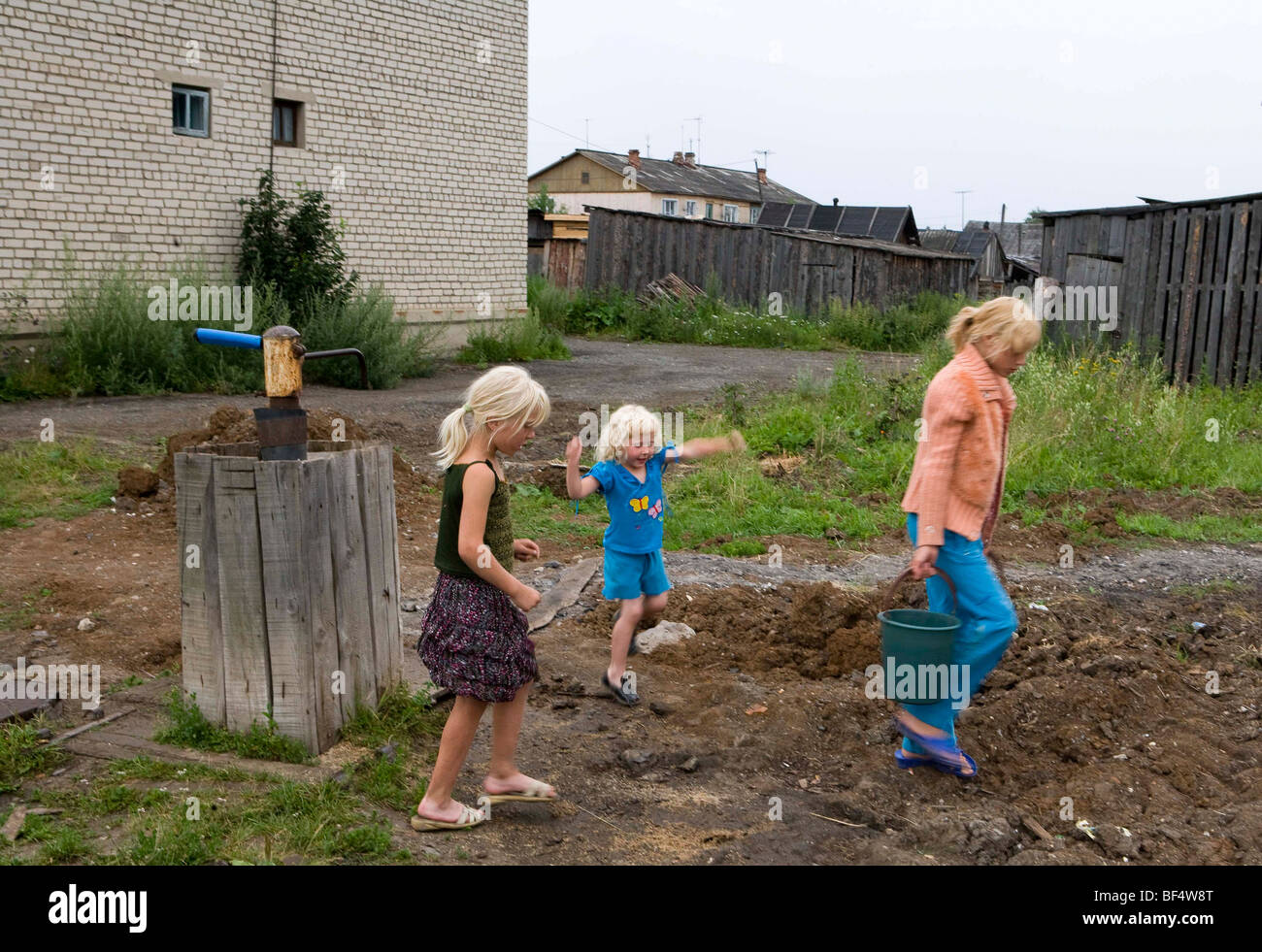 Family fetching bucket of water from water pump in rural Russia Stock Photo