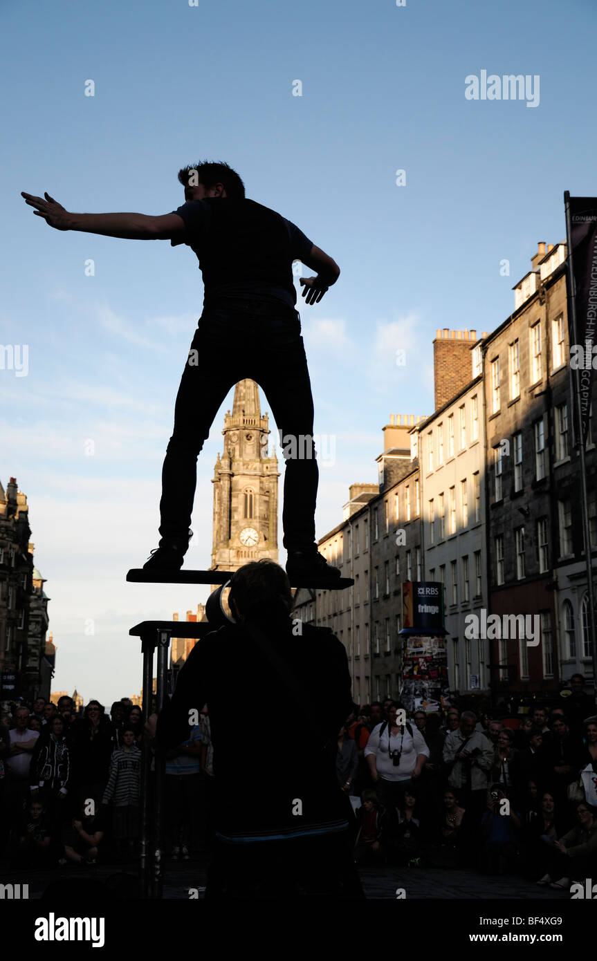 silhouette of a man street performer balancing act finely balanced crowd Edinburgh fringe street festival tilt Stock Photo