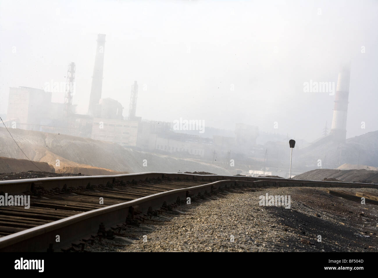 Railway track leading to copper smelting works in pollution haze, Karabash, Urals, Russia Stock Photo