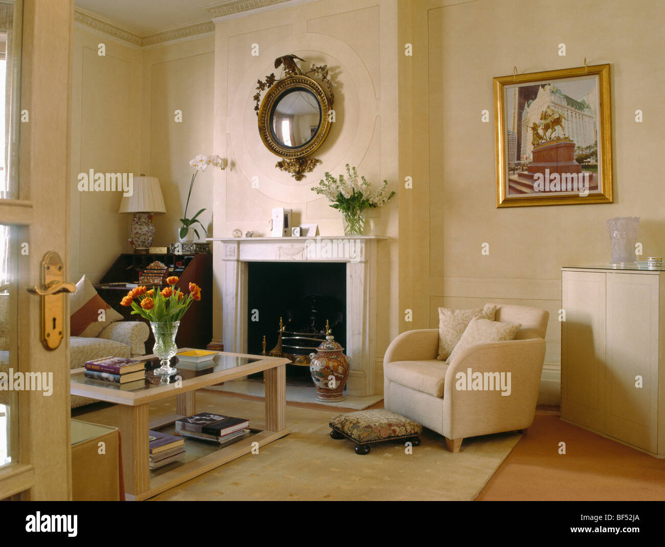 Modern cream armchair beside fireplace in traditional cream living room