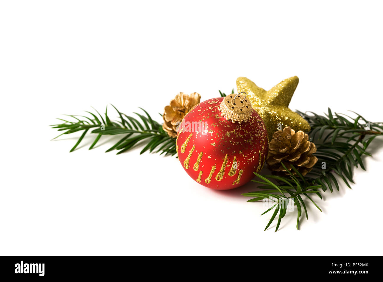 christmas decoration, fir twig with red bauble, golden star and pine cones, cut-out Stock Photo