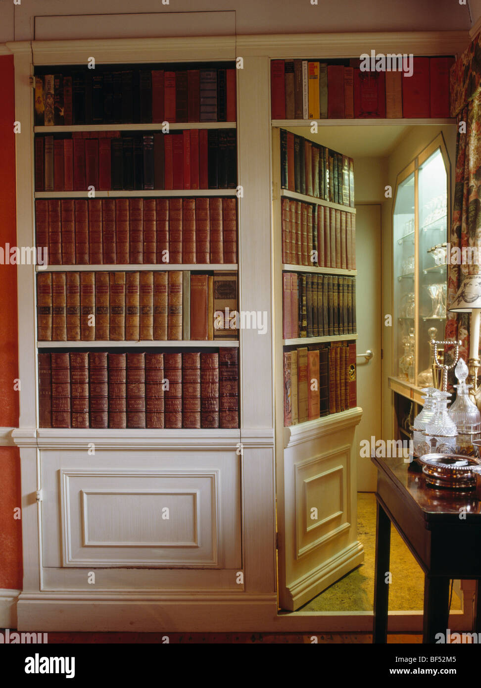 Close-up of small country library with trompe-l'oeil bookshelves concealing doorway Stock Photo