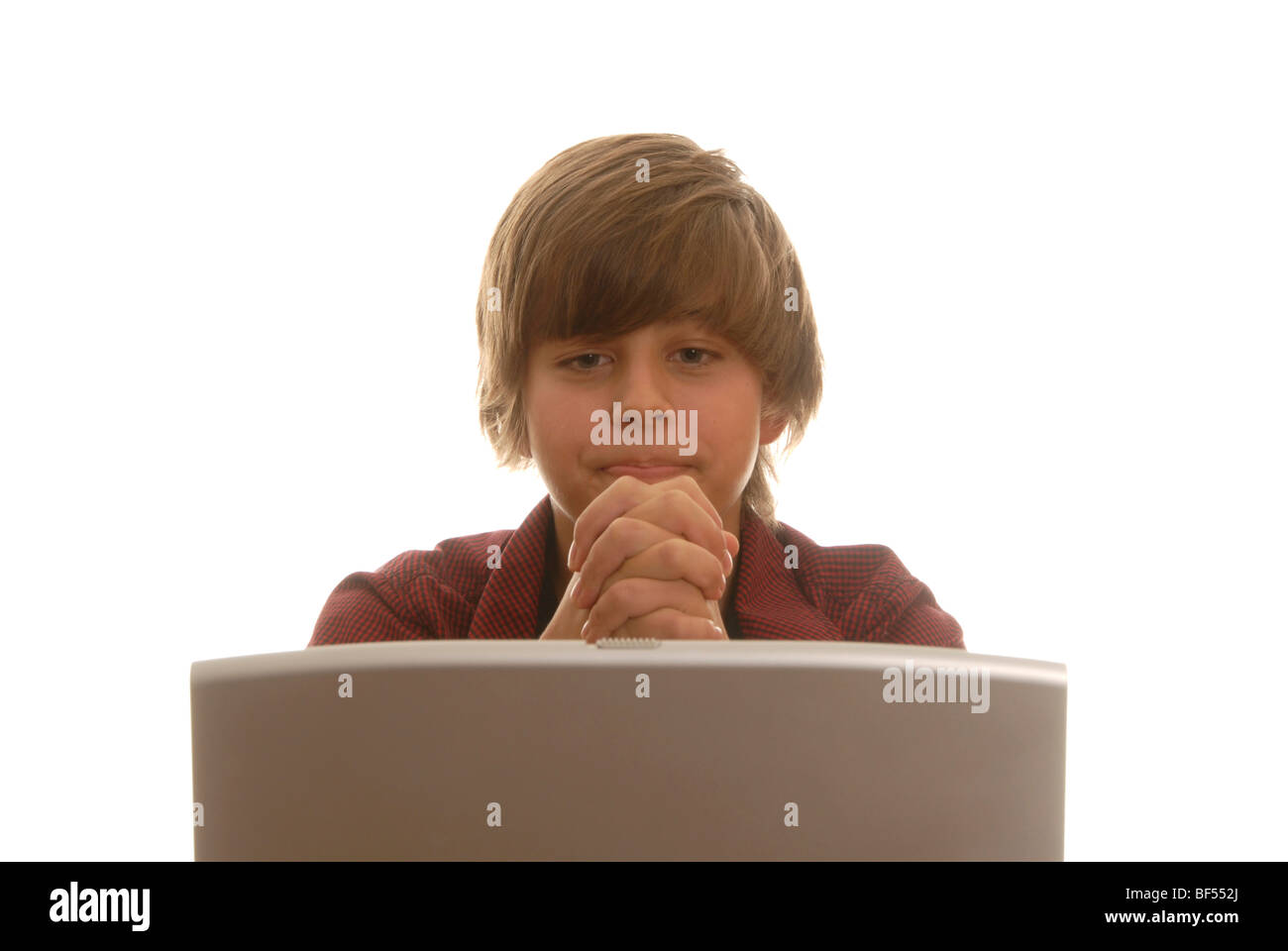 Boy, 16, behind a laptop praying desperately Stock Photo