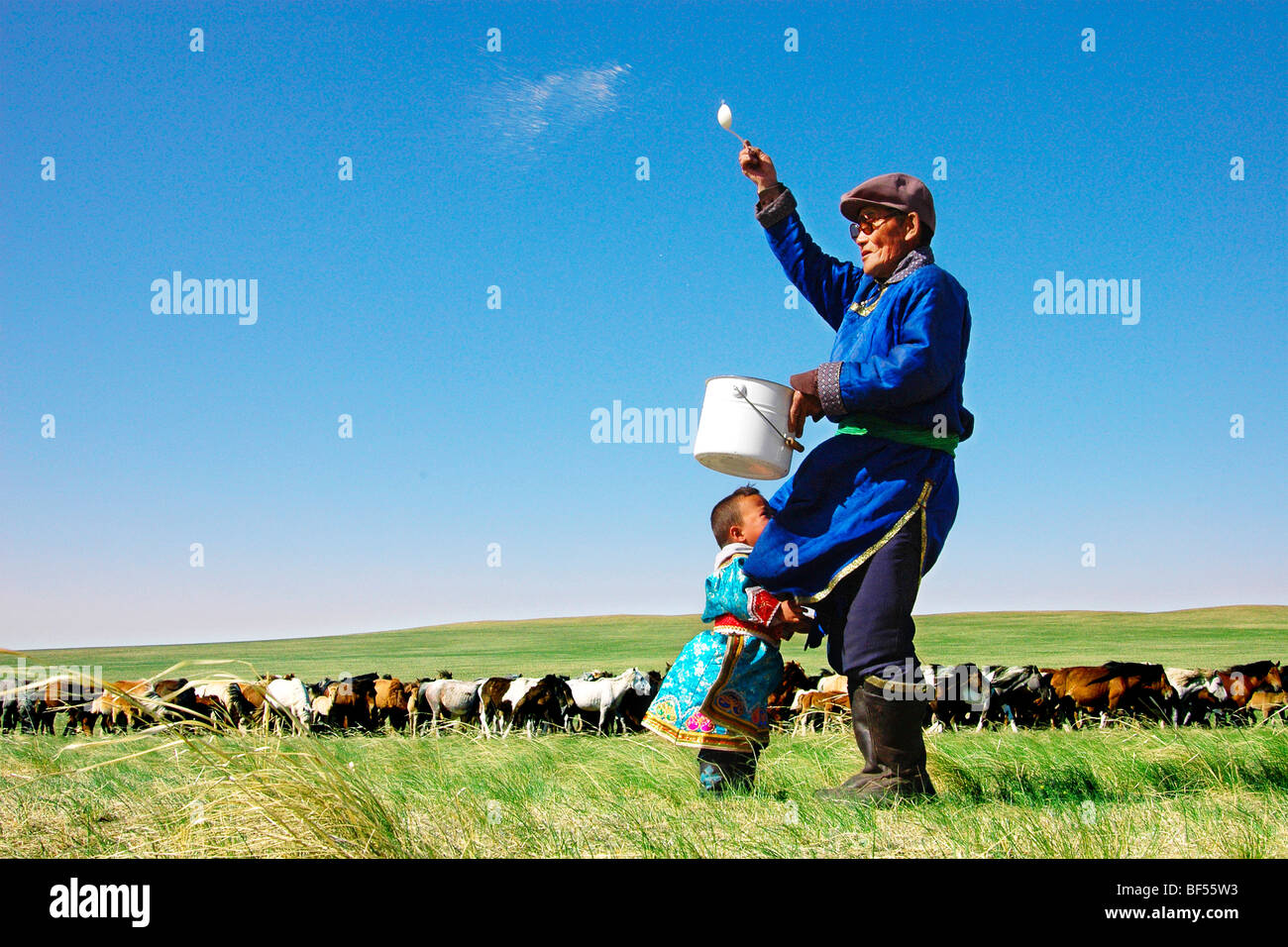 Mongolian man tossing milk to the air for bless, Xilin Gol Grassland, Inner Mongolia Autonomous Region, China Stock Photo