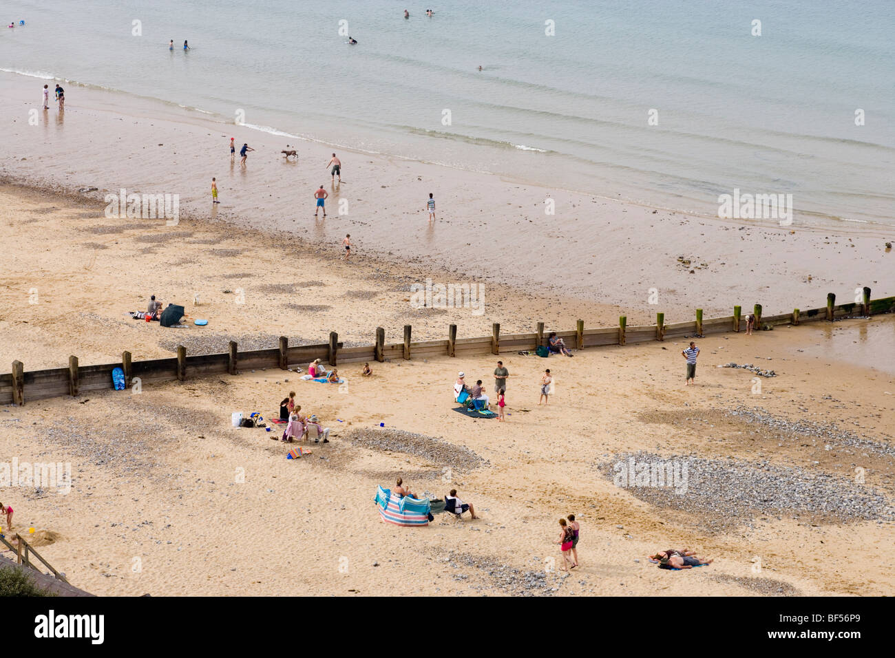 Cromer beach with holidaymakers. Tide going out. August. Norfolk. UK Stock Photo